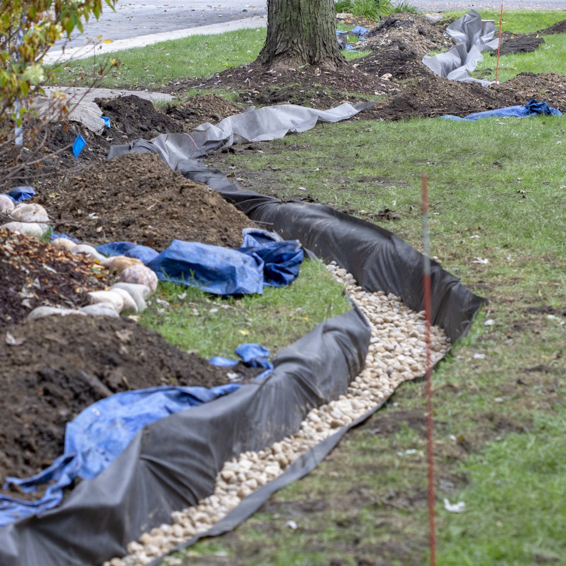 French drain running along front yard with rock-lined swale