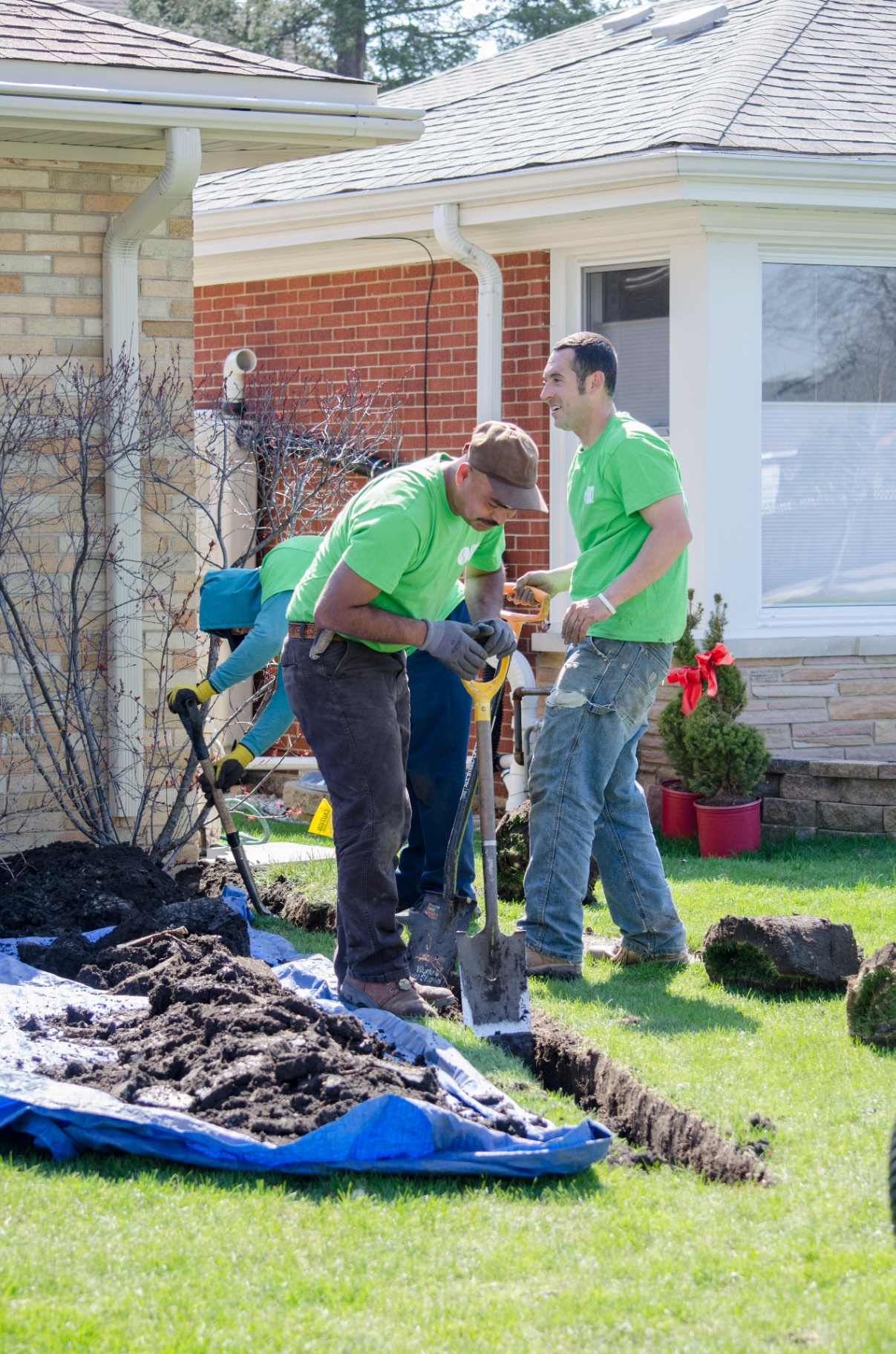 Revive Your Lawn crew working cleanly on drainage trench with tarps down